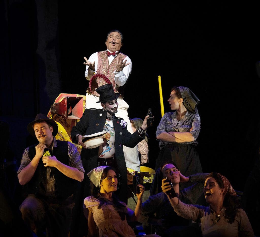 L'elisir d'amore-Dr-Dulcamara-Renato-Girolami-Dulcamaras-Assistant-Maxime-Nourissat-and-members-of-the-Glyndebourne-Chorus