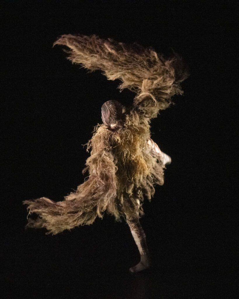 Company Wayne McGregor dancer Salvatore De Simone in fringed costume and headpiece. Wayne McGregor's UniVerse: A Dark Crystal Odyssey, 2023, credit Andrej Uspenski