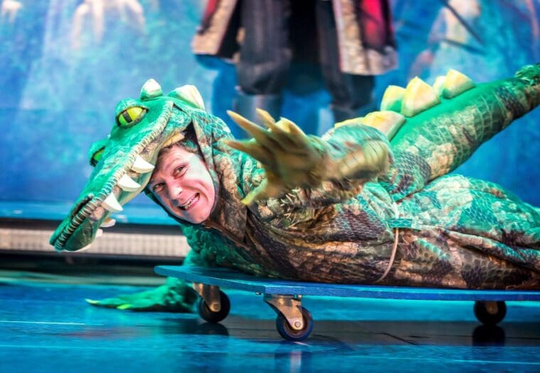Matthew Cavendish play the crocodile on a skateboard in Peter Pan Goes Wrong at the Lyric Theatre London