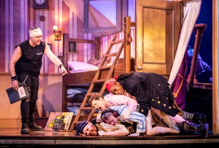 Cast members collapse through a door on set of Peter Pan Goes Wrong at Lyric Theatre London