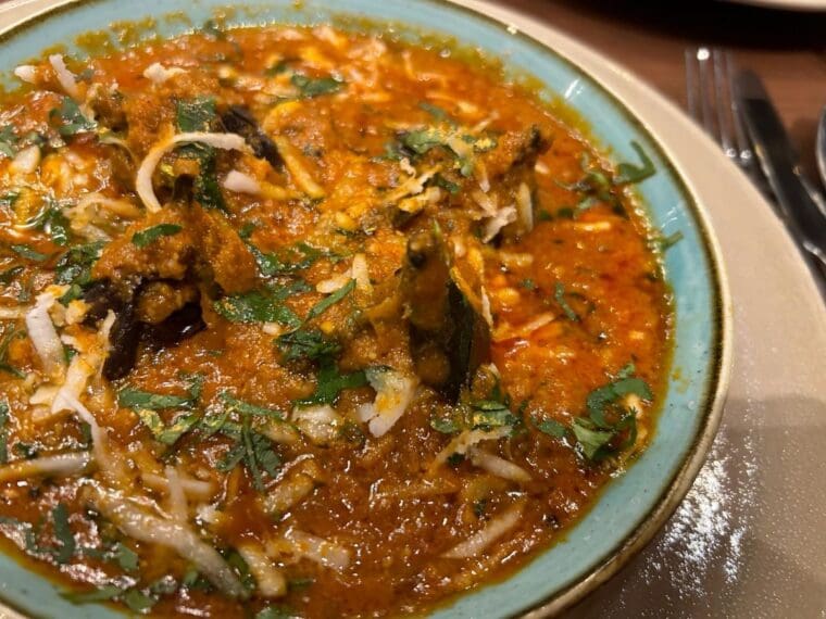 A bowl of curry with baby aubergines served at Colonel Saab Trafalgar Square restaurant