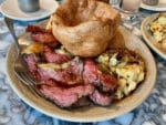Sunday roast dinner beef option served at Duvale's Riverside East restaurant with cauliflower cheese and large Yorkshire pudding on top.