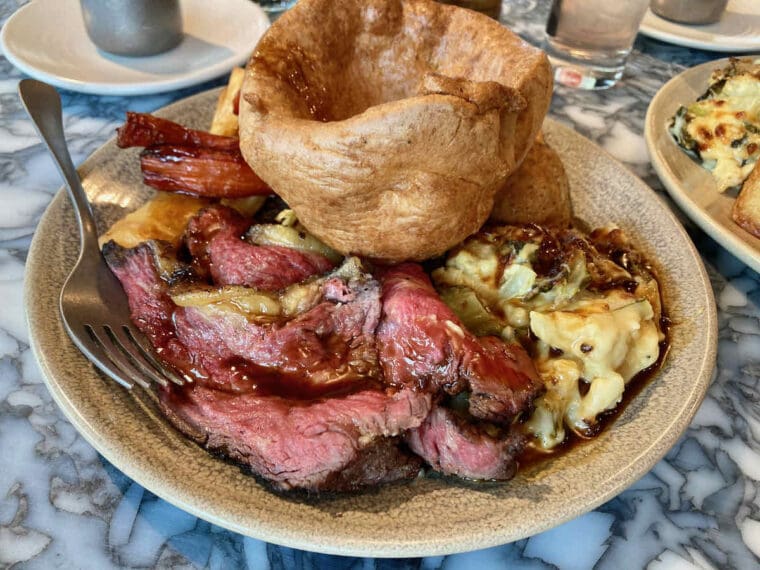 Sunday roast dinner beef option served at Duvale's Riverside East restaurant with cauliflower cheese and large Yorkshire pudding on top.