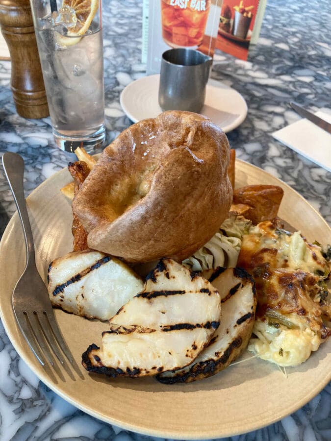 Sunday roast dinner vegetarian option of rosemary and confit garlic baked celeriac served at Duvale's Riverside East restaurant with cauliflower cheese and large Yorkshire pudding on top.