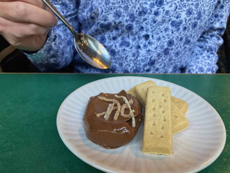 Chocolate mousse dessert on a white plate with three shortbread fingers.