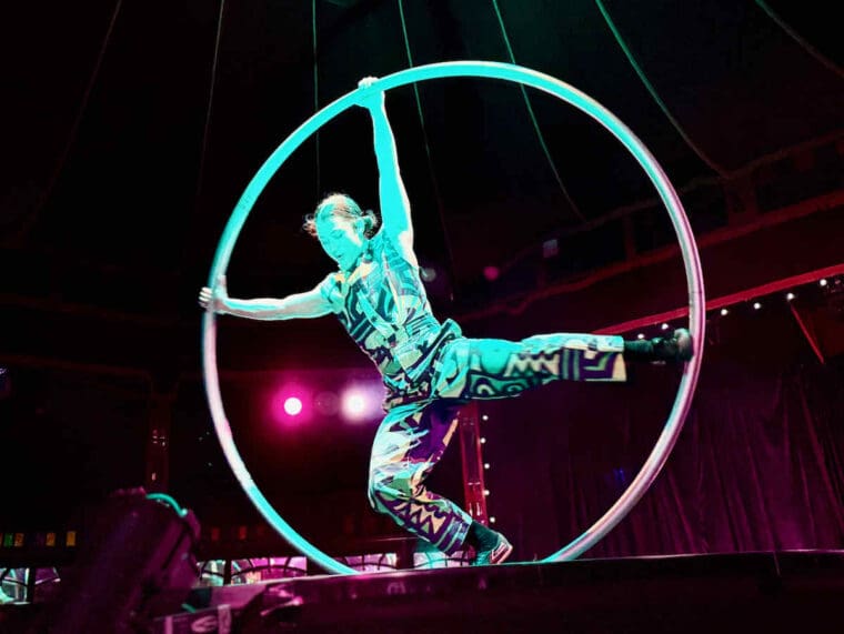 Acrobatic hoop act performed during The Ruckus by Revel Puck Circus; a dancer balances on one leg within a seven foot hoop.