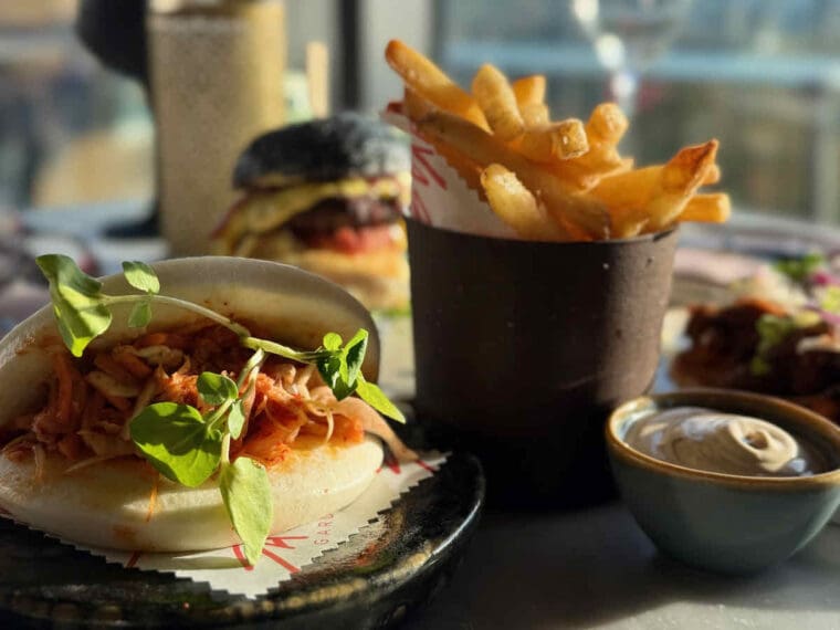 Chicken bao bun with fries and mayo in separate dishes at Savage Garden rooftop bar, Tower Hill, London.