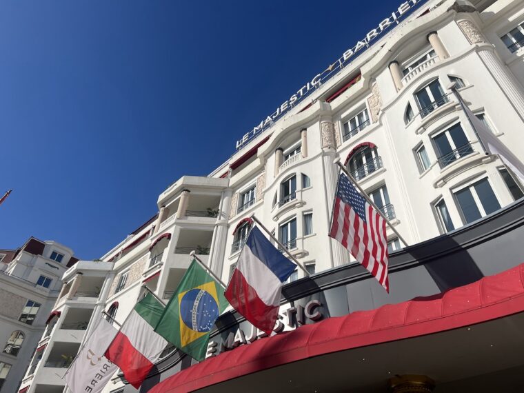 Outside of the Majestic hotel, an art deco building with flags flying in the wind