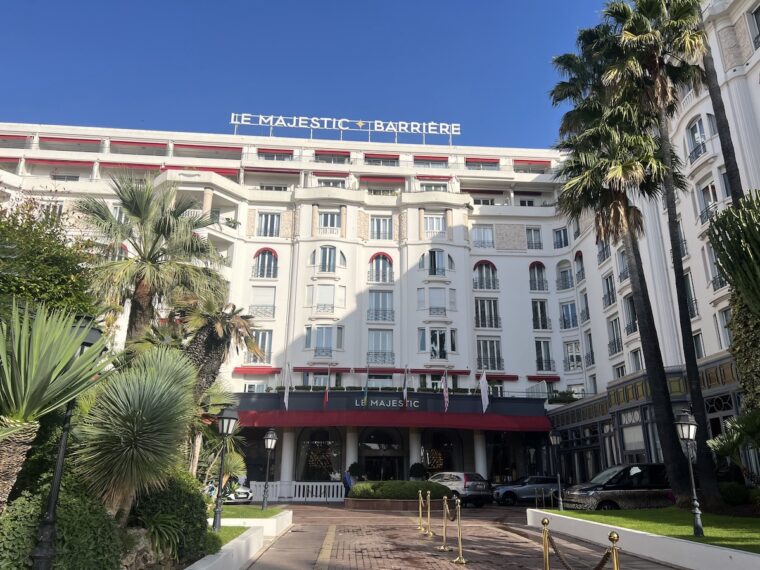 Outside Le Majestic hotel with palm trees on either side