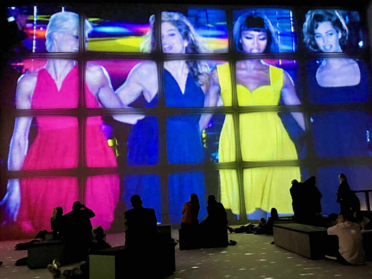 A large 1990s image of Super Models broken up across twenty television screens; as seen at Vogue: Inventing the Runway at Lightroom.
