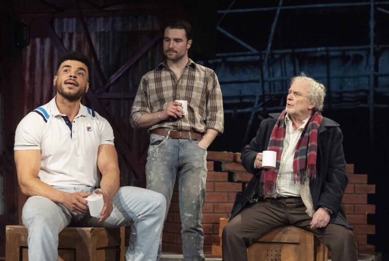 Boys from the blackstuff, cast members sat on stage with brick work in the background