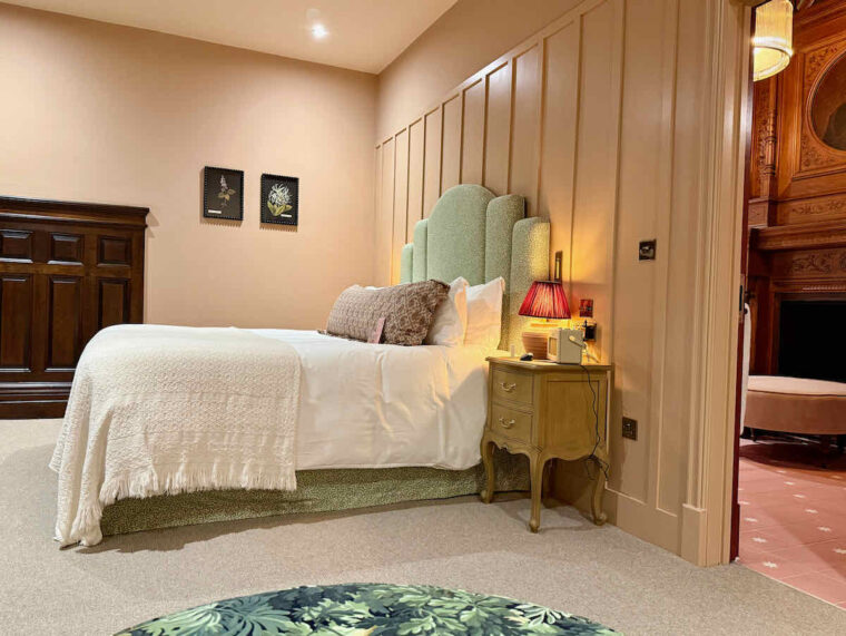 Luxe bedroom at The Royal Forest, Epping Forest, Heartwood Inns. A large bed seen sideways on with pale green headboard
