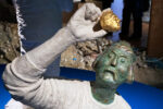Sculpture of a Mudlark examining an artefact at Secrets of the Thames - credit Jeanne Horak