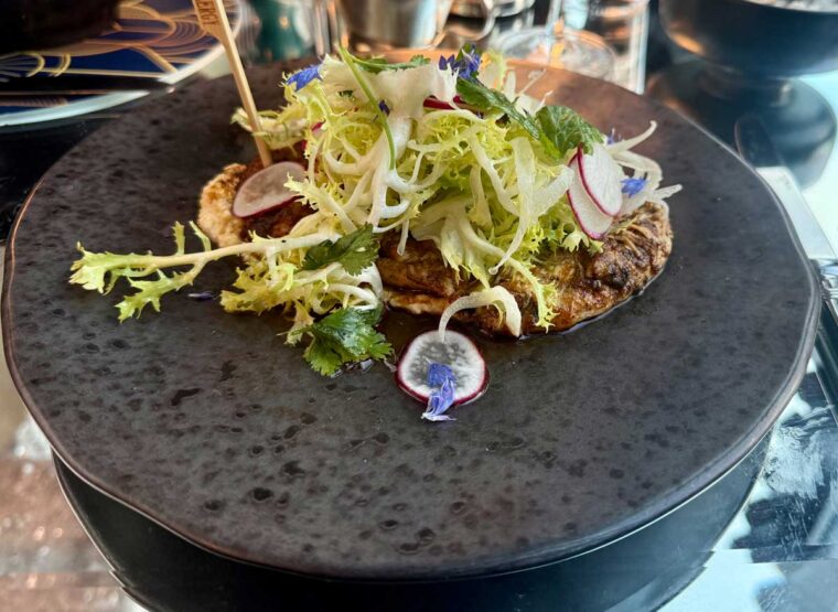Cumin and Oregano chicken with frisee salad on a plate