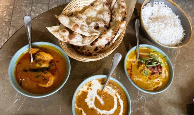 Pre-theatre menu main course dishes at Farzi - Wagyu beef seekh kebab pasanda and prawns machar jhol. Served with  dal makhani, buttered naan and steamed rice