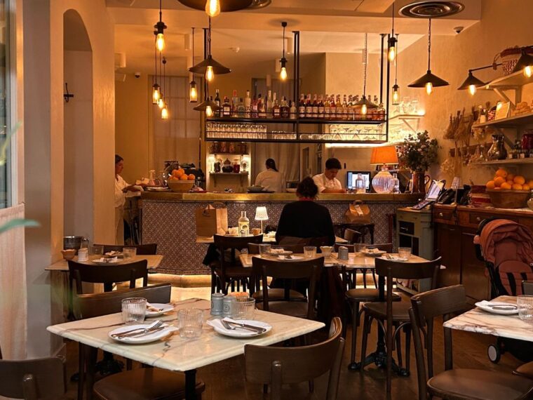 Interior view of Villa Mamas restaurant showing open kitchen and guest seating.
