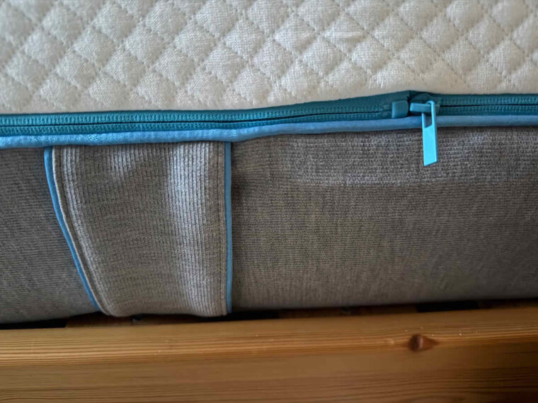 Close up side view of Simba mattress - a blue zip to remove the top cover and grey fabric handles for easy rotation.