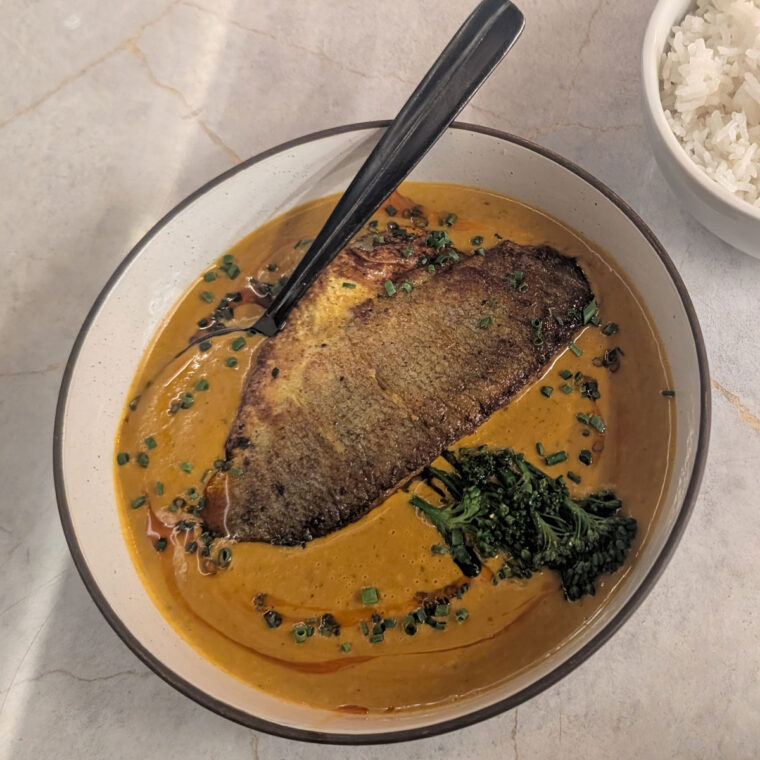 Image of plate of seabass served in a rich orange malabar sauce at Cho Asia restaurant.