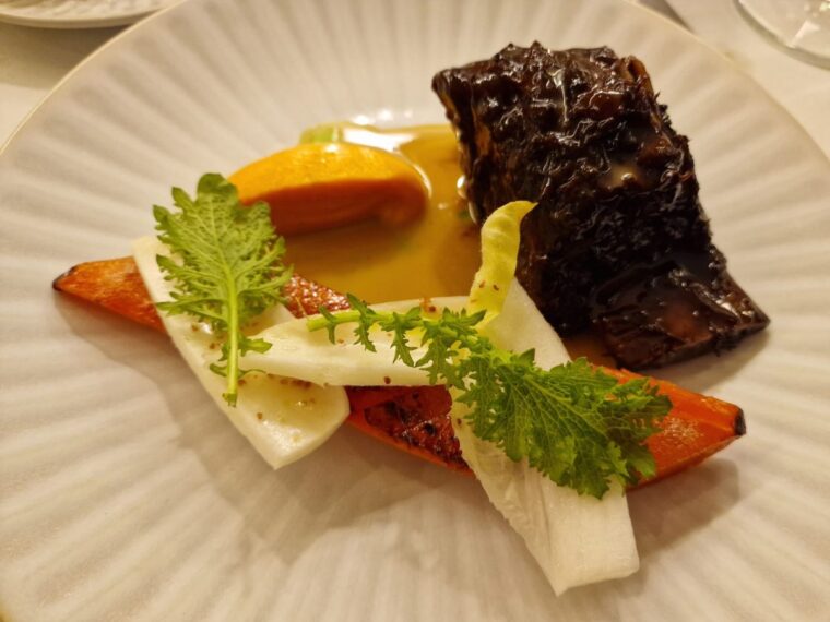 Main course dish of short rib beef with carrot and an endive salad at Orion by Alex Webb