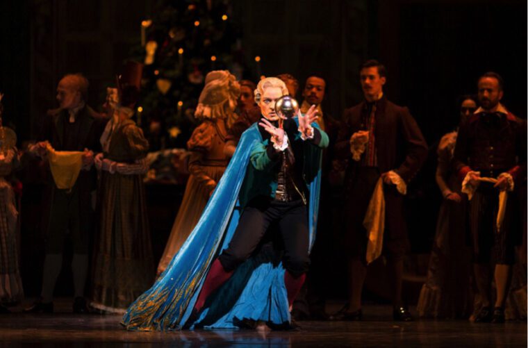 In The Nutcracker, Drosselmeyer in his flowing blue and gold cloak performs a magic trick with a floating sphere