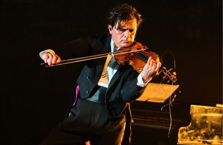The McRae/Vassilev Project. Vasko Vassilev plays a one string violin. You can see the broken strings hanging from he instrument's neck.