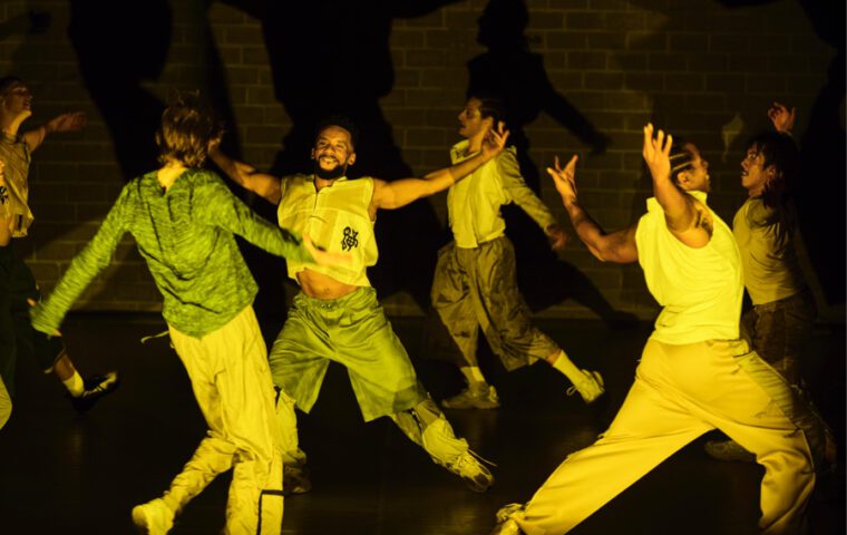 Hang Time: a group of men enjoy a group dance, chests pushed out, arms open wide