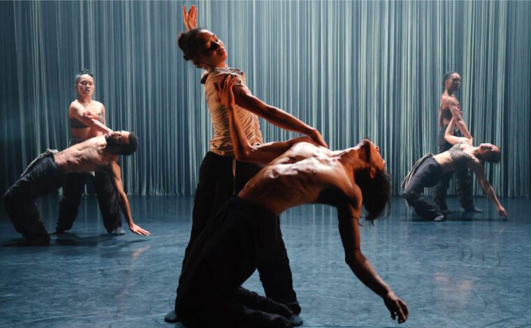 Tellus, three pairs of dancers in the same pose: the men on their knees bending all the way back, the women stanging behind then with one hand on their shoulder